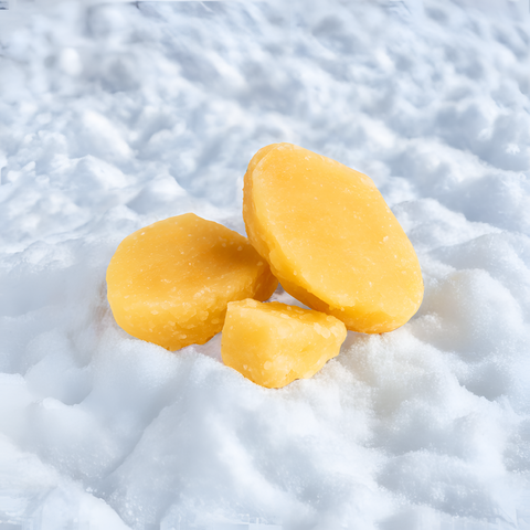 Drei gelbe Cold Cure CBD Dabs liegen im Schnee, Nahaufnahme für hochwertiges Produktbild