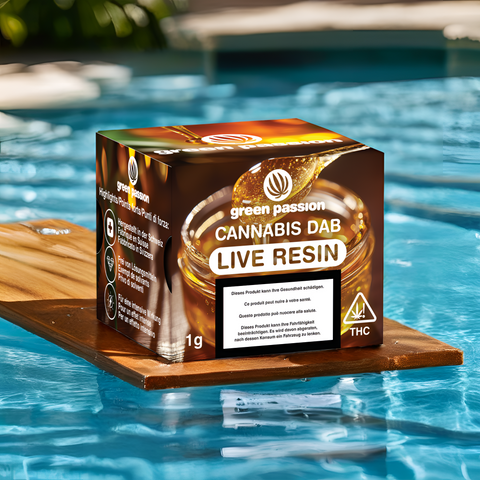 Verpackung des 1g Live Resin CBD Dabs von Green Passion, platziert auf einem Holzbrett am Pool, zeigt goldenes Harz und Produktinformationen.