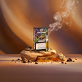 Green Passion Cannabis Vape Cartridge Cookies – Produktbox mit freiliegender Vape-Kartusche auf organischem Sandstein-Podest, umgeben von Chocolate-Chip-Cookies und Schokoladenstücken, mit aufsteigendem Dampf vor warmem Karamell-Hintergrund.