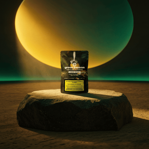 Green Passion Cannabis Flowers Lemon Passion – gelbe 10g Indoor-Packung auf organischem Holzsockel in warmem Goldton-Ambiente mit Prismenreflexen.