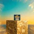 Green Passion Cannabis Dab Sugar Wax 1g Verpackung auf goldenem Sockel vor türkis-orangem Sonnenuntergrund