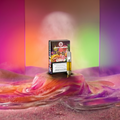Green Passion Cannabis Vape Cartridge Zkittles – Produktbox mit freiliegender Vape-Kartusche auf farbig marmorierter Oberfläche in Pink, Orange und Lila, vor mehrfarbig beleuchteter Kulisse mit aufsteigendem Dampf.