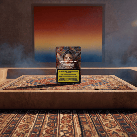 Confezione di hashish Black Afghan di Green Passion su un tappeto decorativo, con un avviso di salute visibile.