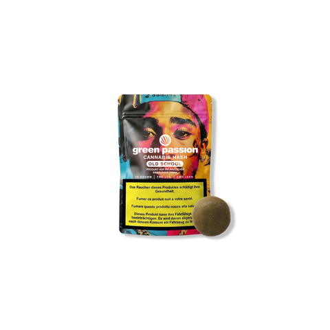 Confezione di cannabis hash Green Passion Old School con avvertenze sulla salute e un pezzo di hashish rotondo accanto.