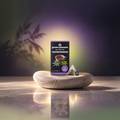 Verpackung von Green Passion Bio-Hanftee mit Brombeer- und Zitronenverbene-Geschmack, daneben ein Teebeutel auf einem Stein.