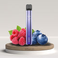 Elfbar 600v2 Vape in lilla tra lamponi freschi e mirtilli, simboleggia il gusto Blueberry Raspberry, su piedistallo di legno.