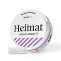 Runde Dose Heimat Nicotine Pouches Frosty Berry mit lila Streifen, daneben ein weißer Nikotinbeutel, Swiss Made-Logo sichtbar.
