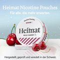 Heimat Nicotine Pouches Wild Cherry vor einem Hintergrund mit frischen Kirschen, die Verpackung betont den fruchtigen Geschmack und die Schweizer Q…
