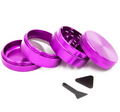 Un grinder en aluminium rose à quatre parties, présenté ouvert, avec tamis et accessoires, sur fond blanc.