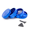 Grinder en aluminium bleu à quatre parties, présenté ouvert, avec tamis et accessoires sur fond blanc.