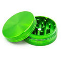 Grinder en aluminium vert à deux parties, présenté ouvert, montrant les dents tranchantes et le design brillant et texturé.