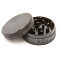 Grinder en aluminium noir à deux parties, présenté ouvert, avec des dents tranchantes et des bords crantés pour un broyage efficace.